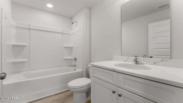 full bathroom featuring vanity, hardwood / wood-style floors, washtub / shower combination, and toilet