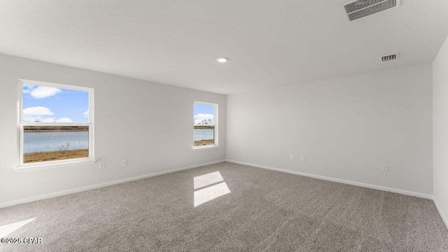 carpeted empty room with a water view