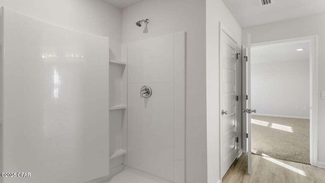 bathroom featuring wood-type flooring and walk in shower