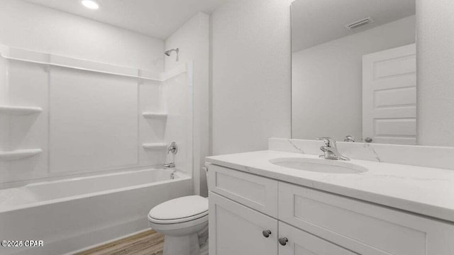 full bathroom with vanity, hardwood / wood-style flooring, shower / bathtub combination, and toilet