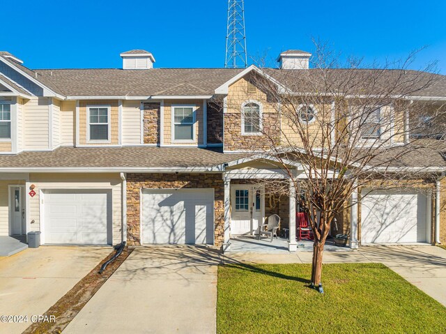 townhome / multi-family property featuring a front yard and a garage