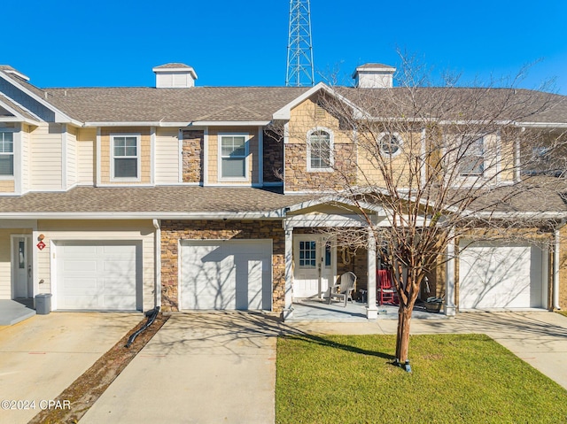 townhome / multi-family property featuring stone siding, roof with shingles, a chimney, and driveway