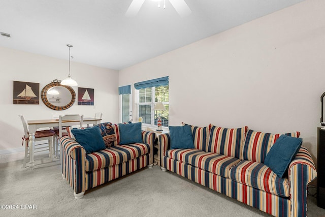 carpeted living area with ceiling fan and visible vents