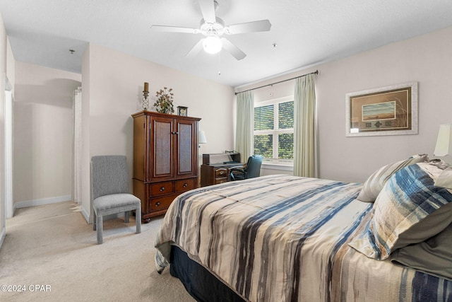 bedroom with ceiling fan, baseboards, and light colored carpet