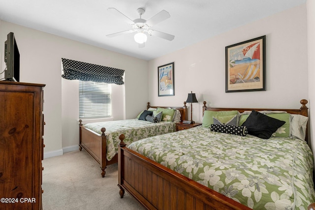 bedroom with ceiling fan, baseboards, and light colored carpet