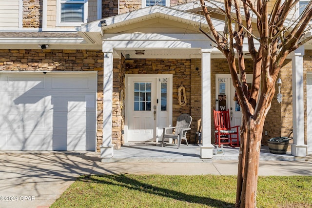 view of exterior entry with stone siding and an attached garage