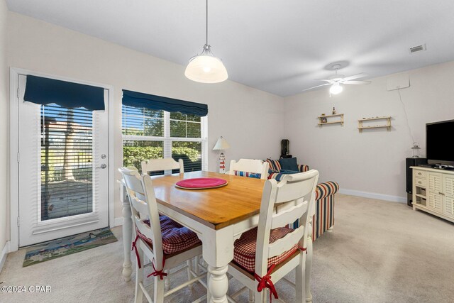 carpeted dining room with ceiling fan