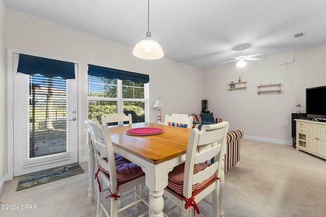 dining area with baseboards, ceiling fan, visible vents, and light colored carpet