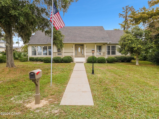 ranch-style home featuring a porch and a front yard