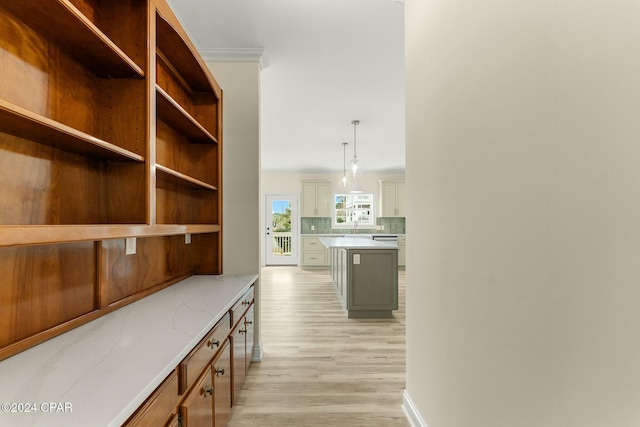 corridor featuring light hardwood / wood-style flooring, ornamental molding, and sink