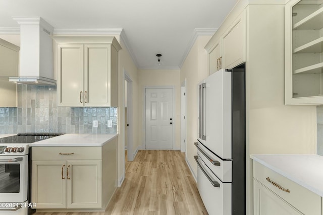 kitchen with decorative backsplash, ornamental molding, wall chimney exhaust hood, white appliances, and light hardwood / wood-style flooring