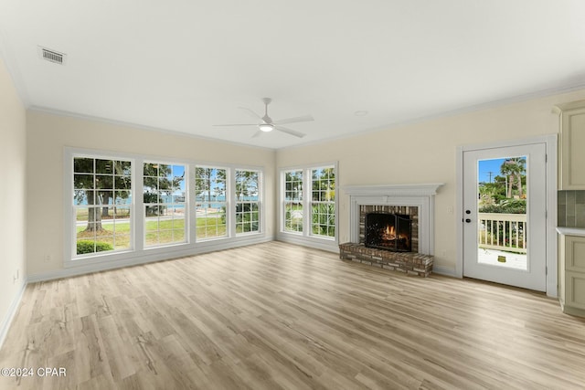 unfurnished living room with ceiling fan, a healthy amount of sunlight, light hardwood / wood-style floors, and crown molding