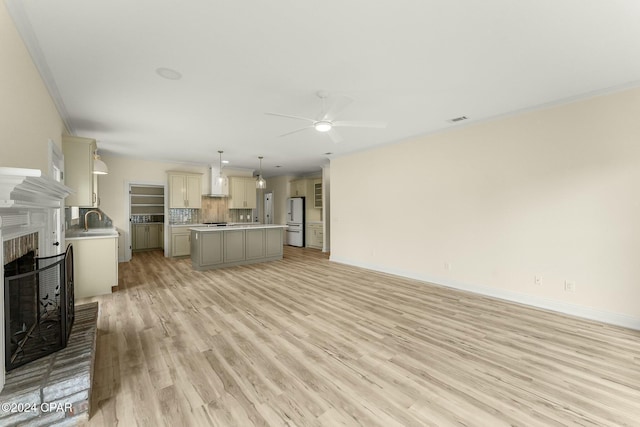 living room with light hardwood / wood-style floors, ceiling fan, crown molding, and sink