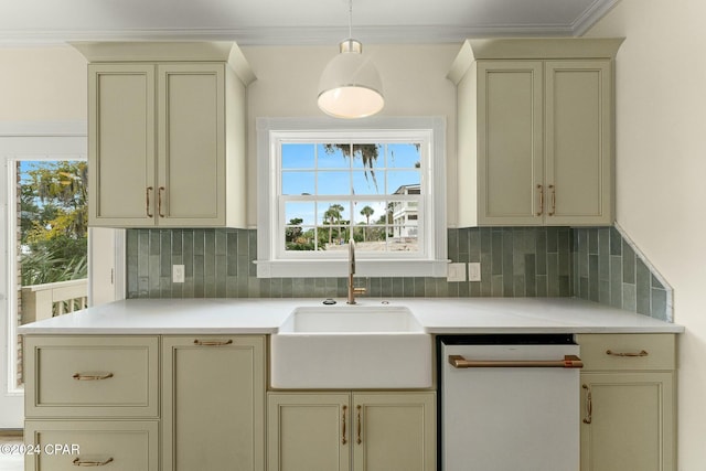 kitchen featuring white dishwasher, crown molding, sink, cream cabinets, and pendant lighting