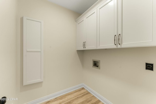 laundry area with hookup for an electric dryer, washer hookup, light hardwood / wood-style flooring, and cabinets