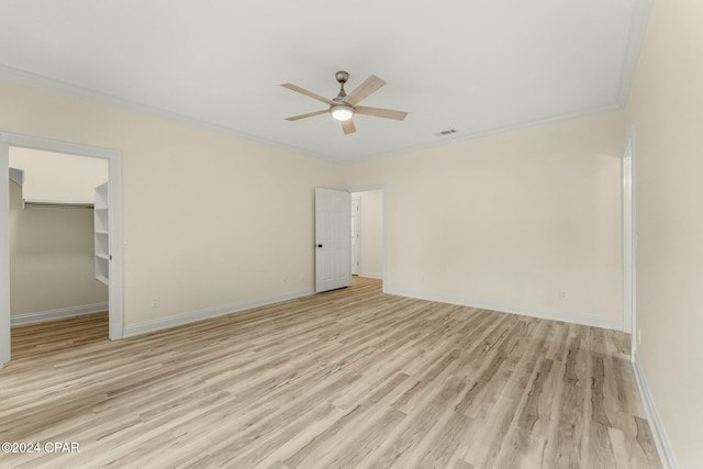 unfurnished bedroom featuring ornamental molding, ceiling fan, a spacious closet, light hardwood / wood-style floors, and a closet