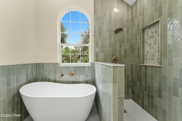 bathroom featuring tile walls and shower with separate bathtub