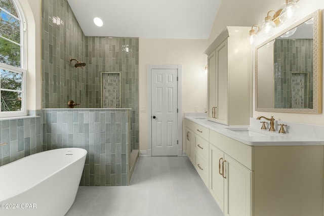 bathroom with shower with separate bathtub, vanity, tile patterned floors, and tile walls