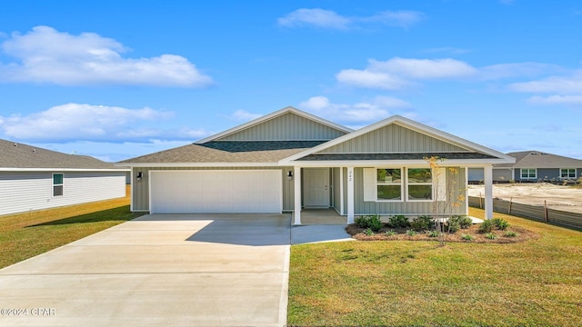 view of front of property with a front lawn, covered porch, and a garage