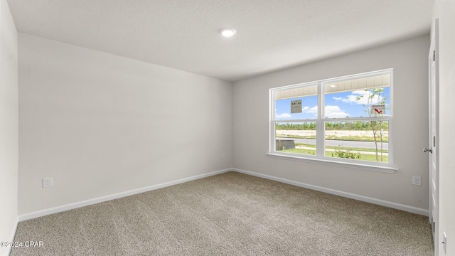 carpeted spare room with a textured ceiling