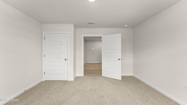 unfurnished bedroom with carpet and a textured ceiling