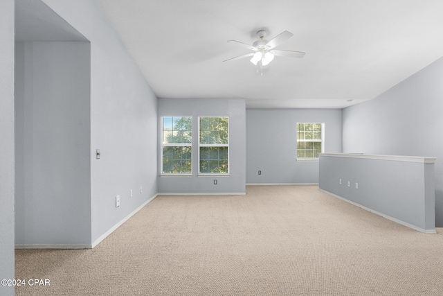 spare room featuring ceiling fan and light colored carpet