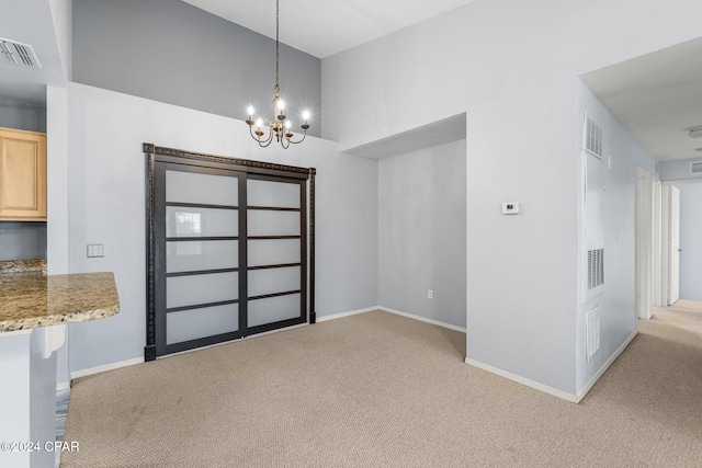 unfurnished dining area with light carpet and an inviting chandelier