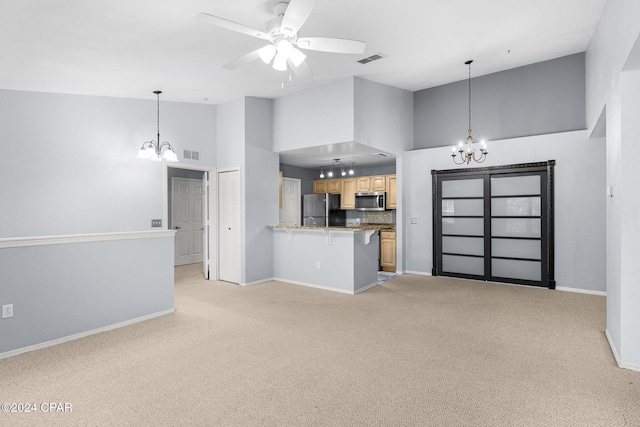 kitchen featuring kitchen peninsula, a high ceiling, stainless steel appliances, and light carpet