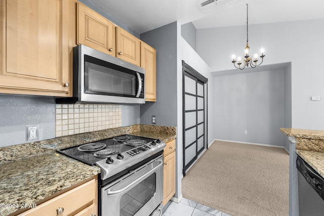 kitchen featuring appliances with stainless steel finishes, dark stone counters, light brown cabinets, a notable chandelier, and lofted ceiling