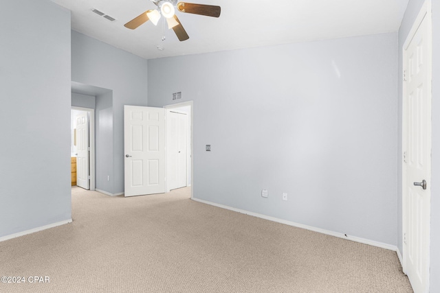 empty room featuring ceiling fan and light colored carpet