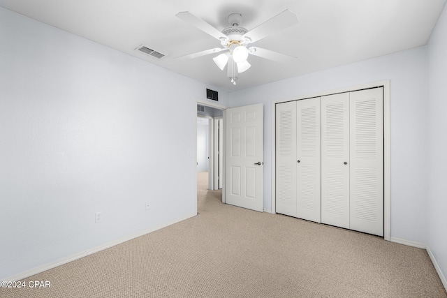 unfurnished bedroom featuring ceiling fan, a closet, and light carpet