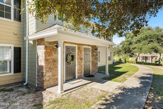 property entrance featuring a lawn