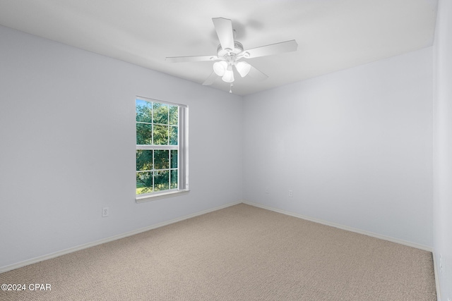 carpeted spare room featuring ceiling fan