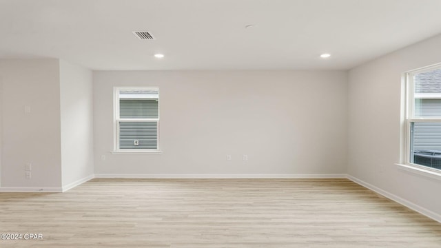 empty room featuring plenty of natural light and light hardwood / wood-style floors