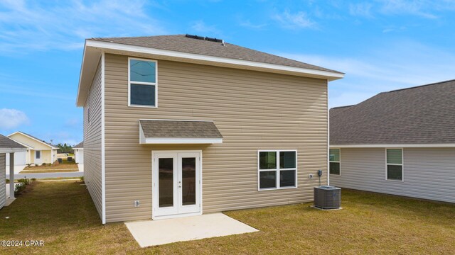 back of property featuring central air condition unit, a yard, and french doors