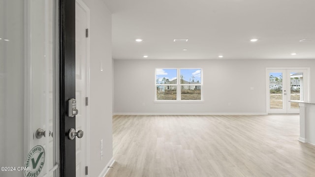 unfurnished room with french doors and light wood-type flooring