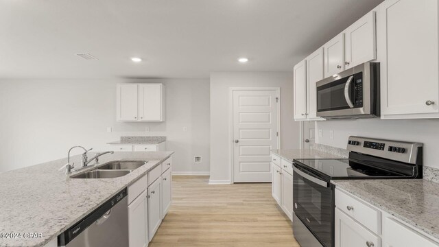 kitchen featuring white cabinets, appliances with stainless steel finishes, light hardwood / wood-style flooring, and sink