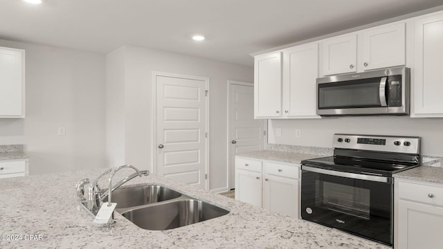 kitchen featuring light stone counters, sink, white cabinets, and stainless steel appliances