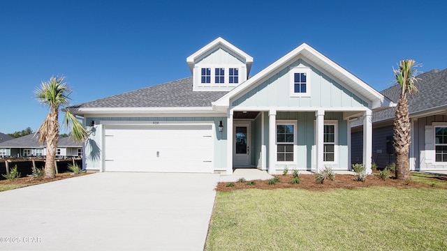 926 Crystal Bayou Blvd, Panama City Beach, FL 32407 - view of front of house featuring driveway, board and batten siding, a front yard, a shingled roof, and a garage