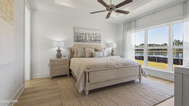 926 Crystal Bayou Blvd, Panama City Beach, FL 32407 - bedroom with baseboards, a water view, light wood-style floors, and ceiling fan