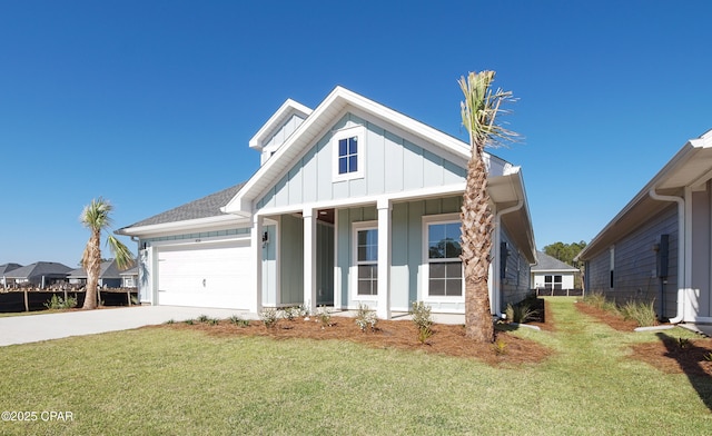 view of front of house featuring a front yard, an attached garage, board and batten siding, and driveway