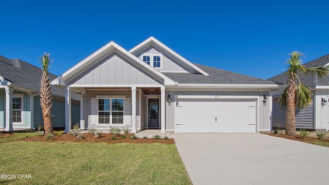 view of front of home with board and batten siding, a shingled roof, a front yard, a garage, and driveway