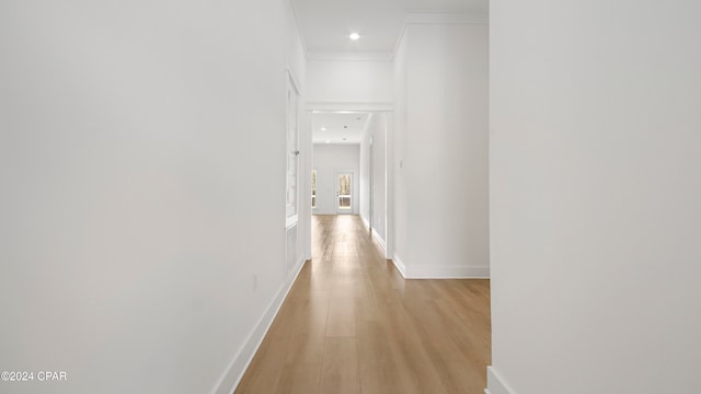 hallway with crown molding and light hardwood / wood-style flooring