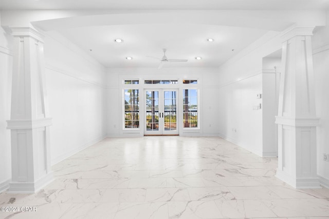 spare room with french doors, ceiling fan, and decorative columns