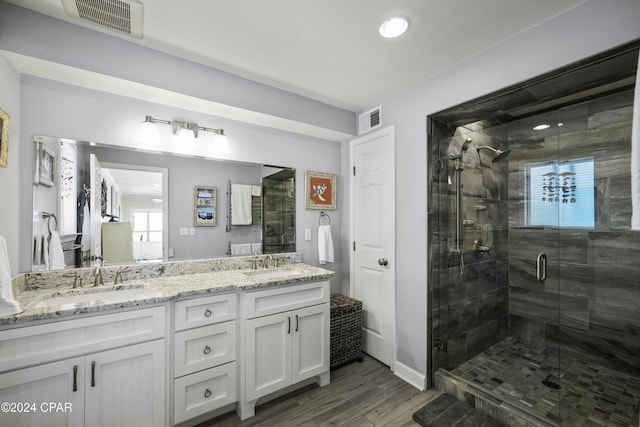 bathroom featuring vanity, hardwood / wood-style flooring, and a shower with door