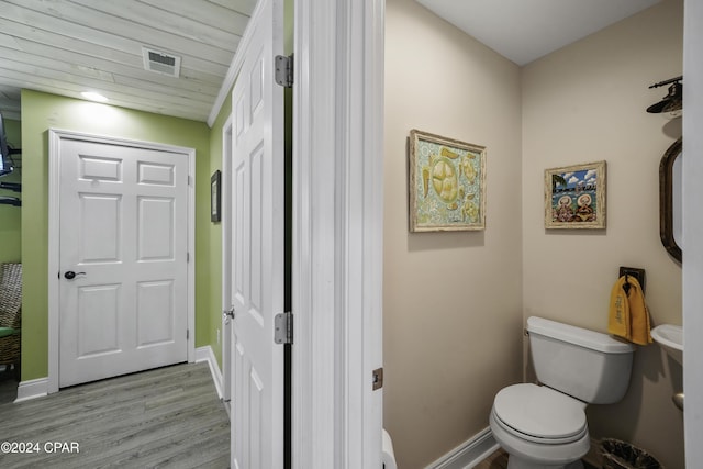 bathroom with toilet and hardwood / wood-style flooring