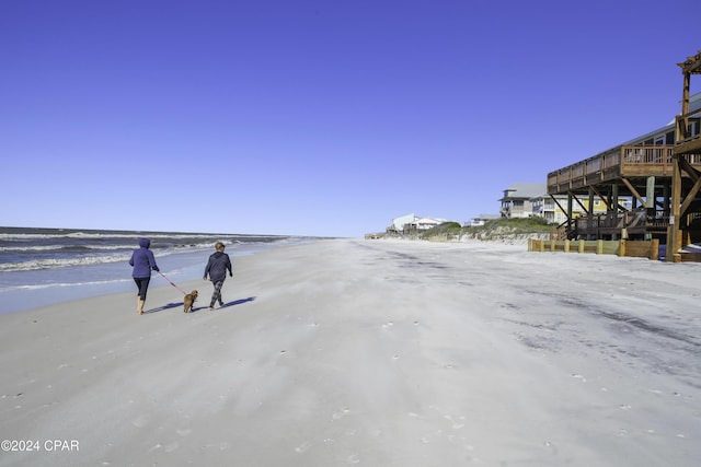 view of property's community with a water view and a beach view