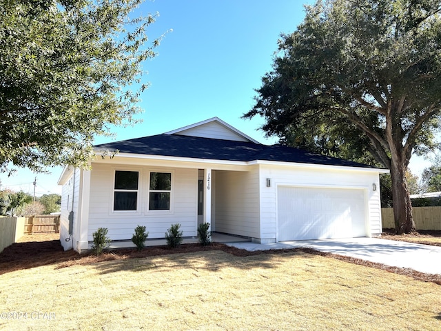 ranch-style house featuring a garage and a front lawn