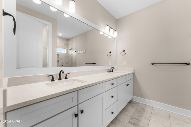 bathroom with tile patterned flooring, vanity, and tiled shower