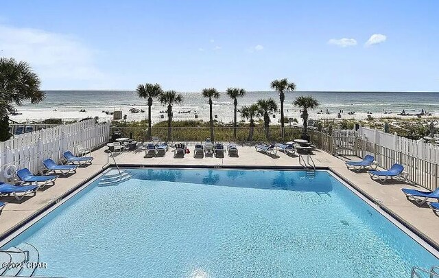 view of pool with a water view and a patio